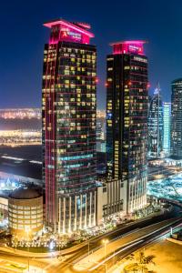 eine Skyline der Stadt in der Nacht mit hohen Gebäuden in der Unterkunft Marriott Marquis City Center Doha Hotel in Doha