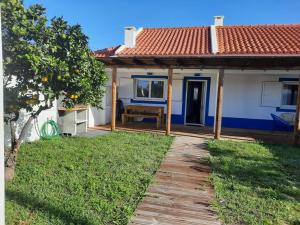 a house with a wooden walkway next to a yard at Sado House 2 in Comporta