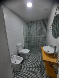 a bathroom with a white toilet and a sink at Sado House 2 in Comporta
