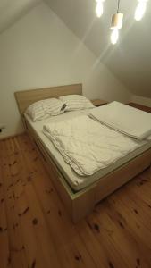 duże łóżko w pokoju z drewnianą podłogą w obiekcie OJRZEŃ 