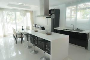 a kitchen with a white counter and a table and chairs at Nirvana Hua Hin Pool Villa in Phetchaburi