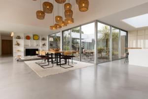 een woonkamer met een tafel en stoelen en een open haard bij Casa da Rocha by White Exclusive Suites & Villas in Lagoa