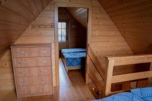 drewniany domek z sypialnią i łóżkiem w obiekcie Domki nad jeziorem-Wodnik w mieście Zarzecze