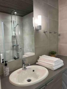 a bathroom with a sink and a mirror and towels at Ruka Chalet Front Base in Ruka