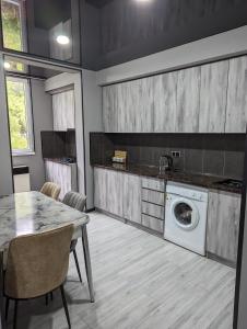 a kitchen with a washing machine and a table at Gari's apartment next to Borjomi Central Park in Borjomi