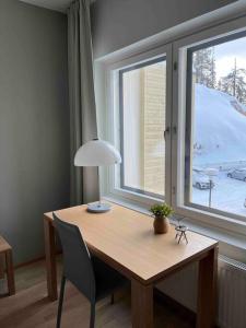 a desk with a lamp and a window in a room at Ruka Chalet Front Base in Ruka