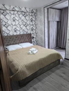 a bedroom with a bed with a stone wall at Gari's apartment next to Borjomi Central Park in Borjomi