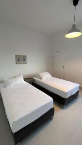 Duas camas individuais num quarto com um candeeiro. em Qash Villas em Jericó
