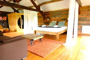 een slaapkamer met een bed in een kamer met houten wanden bij LE MOULIN DE TANQUEUX in Cerny