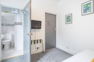 a bathroom with a toilet and a tv on the wall at Milton House Private Room 2 in Cambridge - Perfect for Contractors and Solo Traveler in Chesterton