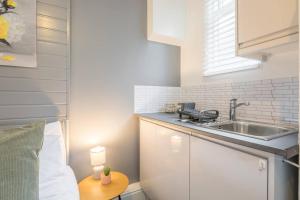 a small kitchen with a sink and a table at Milton House Private Room 2 in Cambridge - Perfect for Contractors and Solo Traveler in Chesterton