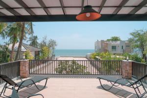 a patio with chairs and a view of the ocean at Nirvana Hua Hin Pool Villa in Phetchaburi