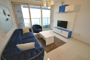 un soggiorno con divano blu e TV di Kaplan Suites 157 a Istanbul