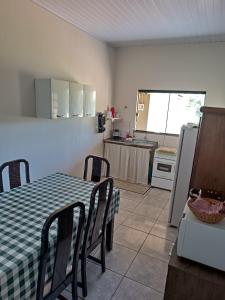 uma cozinha e sala de jantar com uma mesa e um frigorífico em Casa Ana em Dourados