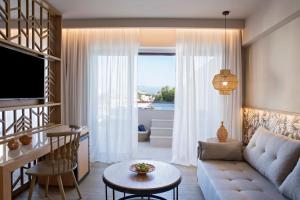 a living room with a couch and a table at Wyndham Grand Crete Mirabello Bay in Agios Nikolaos