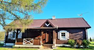 una pequeña casa de madera con techo rojo en Podlaski Zakątek, en Bereżyszcze