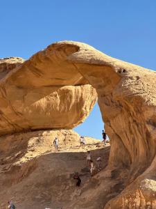 a group of people walking through a rock formation at Tareqzwy wadi rum in Wadi Rum