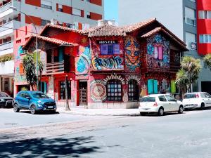 un edificio colorido con coches estacionados frente a él en Hostel El Rejunte en Mar del Plata