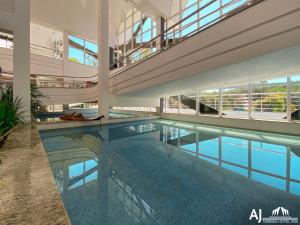 a large swimming pool in a building with a staircase at AJ TERMAS HOTEL IRAÍ in Iraí