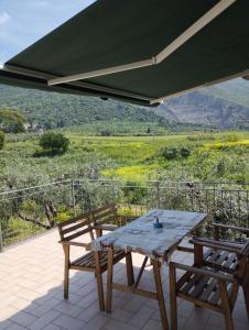 - une table de pique-nique et des chaises sur une terrasse avec vue dans l'établissement L'oasi di Alice, à Sermoneta