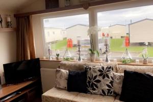 a living room with a couch and a large window at Whitley bay caravan retreat in Whitley Bay