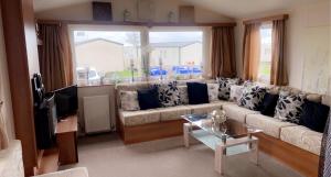 a living room with a couch and a window at Whitley bay caravan retreat in Whitley Bay