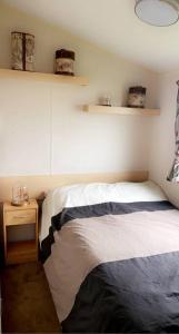 a bedroom with a bed and a table with a night stand at Whitley bay caravan retreat in Whitley Bay
