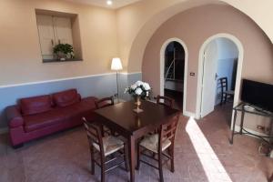 a living room with a table and a couch at La Casetta Rosa alloggio indipendente, four beds in Mascalucia