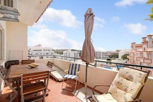 a balcony with a table and chairs and an umbrella at T3 Duplex Albufeira in Olhos de Água