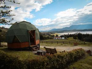 a dome tent in a field with a bench at GLAMCAPTOUR in Guatavita