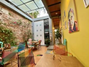 a room with tables and chairs and a brick wall at Imagine hostel in Santa Marta