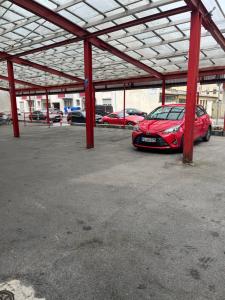 a red car parked in a parking lot at Hipokratios 3 Zimmer mit Gemeinschaft WC in Fürth