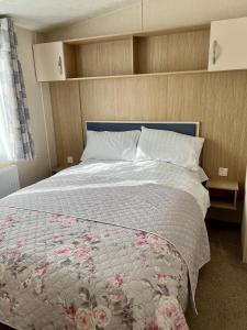 ein Schlafzimmer mit einem großen Bett mit Blumen darauf in der Unterkunft Bude holiday home in Bude