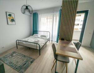 a bedroom with a bed and a table and a chair at Your New and Modern Home in Bucharest