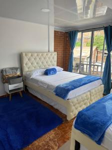 sypialnia z 2 łóżkami i oknem w obiekcie Apartamentos Quimbaya w mieście Quimbaya