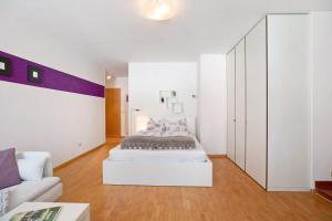 a white room with a bed and a couch at Appartement Wally in Appiano sulla Strada del Vino