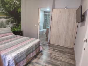 a bedroom with a bed and a door to a bathroom at Hostal El Bosque Encantado Toledo in Toledo