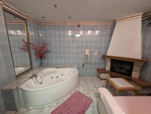 a bathroom with a large tub and a fireplace at Motel DRABEK in Tarnowskie Góry