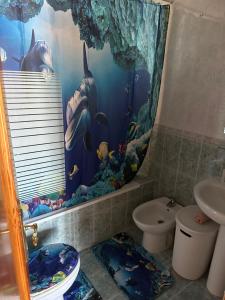 a bathroom with a dolphin shower curtain and a toilet at Cantiño in Estepona