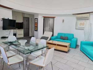 uma sala de estar com uma mesa de vidro e cadeiras em Villa Sol 9 em Tías