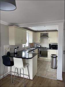 a kitchen with white cabinets and a black counter top at Yew Tree Court in Heswall
