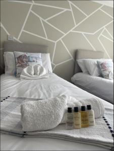 a white bed with three bottles of lotion on it at Yew Tree Court in Heswall