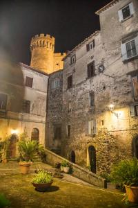 un antiguo edificio de piedra con un castillo por la noche en La Piazzetta, en Bracciano