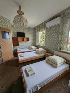 1 dormitorio con 2 camas y lámpara de araña en Motel DRABEK, en Tarnowskie Góry