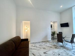uma sala de estar com um sofá e uma mesa em Da Mariella case vacanza - Bilocale Roma 104 em Sanremo
