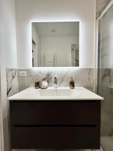 uma casa de banho com um lavatório e um espelho em Da Mariella case vacanza - Bilocale Roma 104 em Sanremo