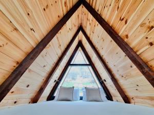 a bedroom in a tree house with a window at Fern Farm Tiny Home in Mojkovac