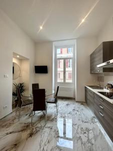 uma cozinha com mesa e cadeiras num quarto em Da Mariella case vacanza - Bilocale Roma 104 em Sanremo