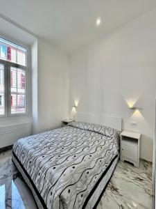 um quarto branco com uma cama grande e uma janela em Da Mariella case vacanza - Bilocale Roma 104 em Sanremo
