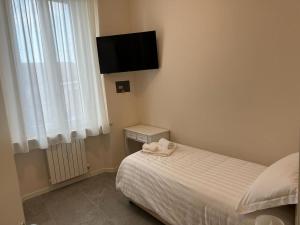 a bedroom with a bed and a tv on the wall at Hotel Il Duca barbablu in Sabbioneta